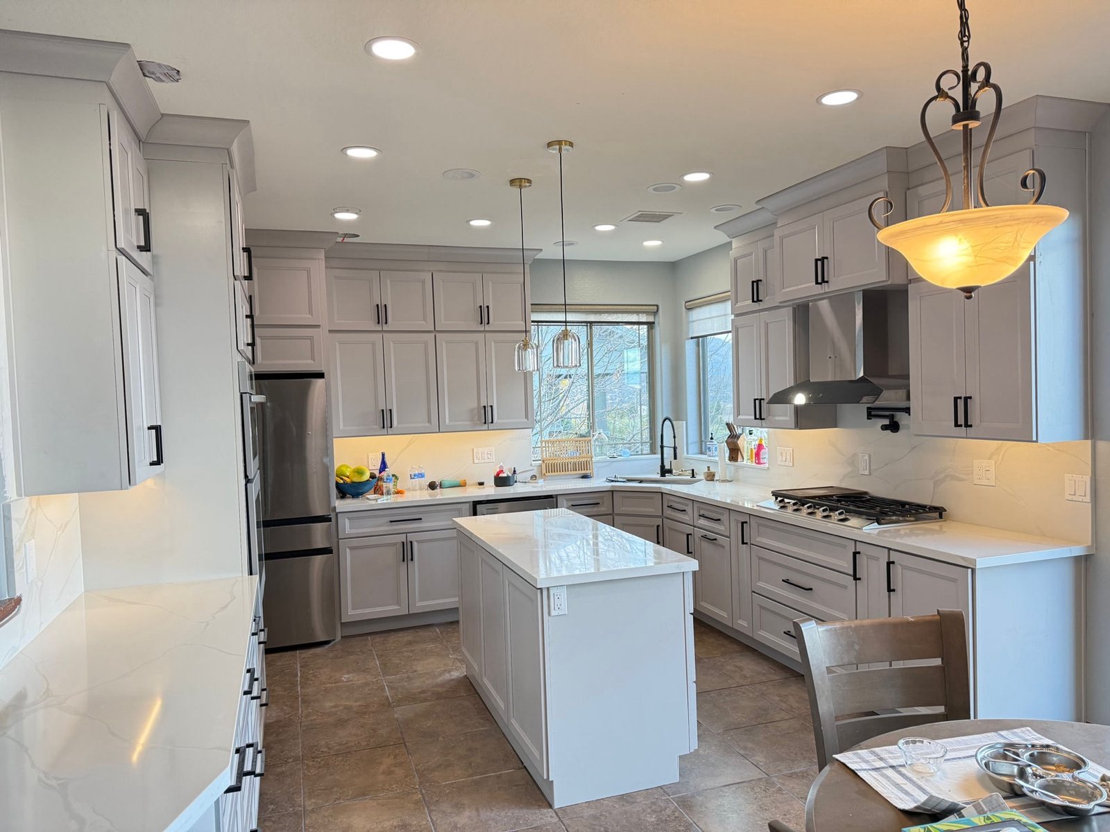 Full gray kitchen remodel with quartz island and black hardware