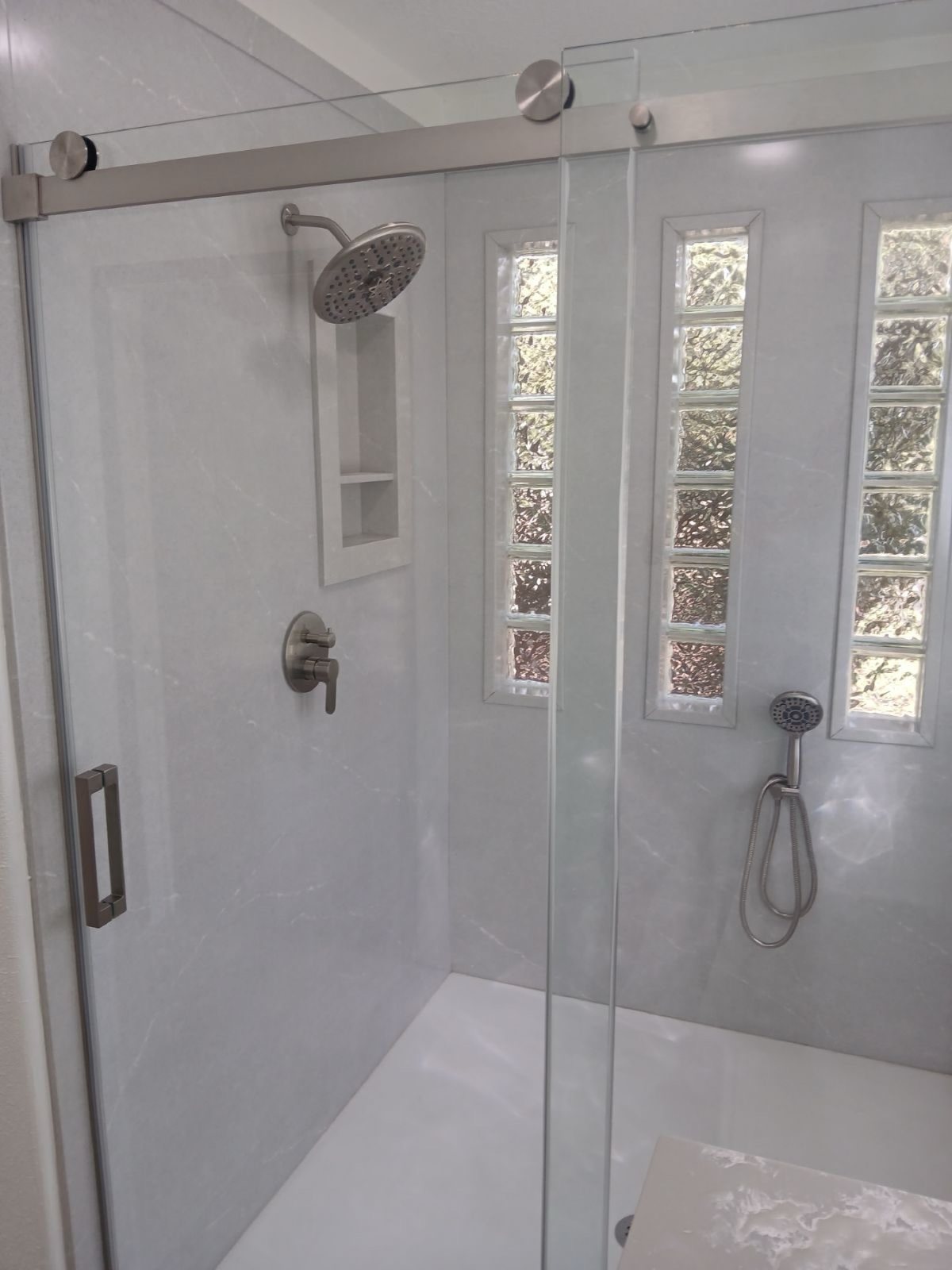 Groutless shower panels with sliding glass door and glass block windows