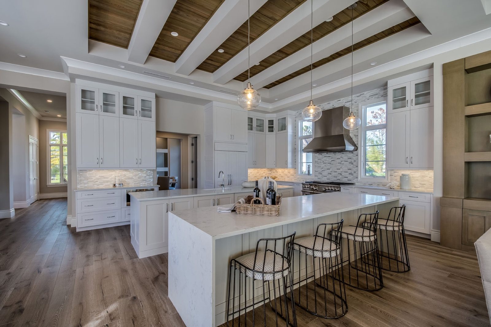 Luxury white kitchen with coffered wood ceiling and marble island