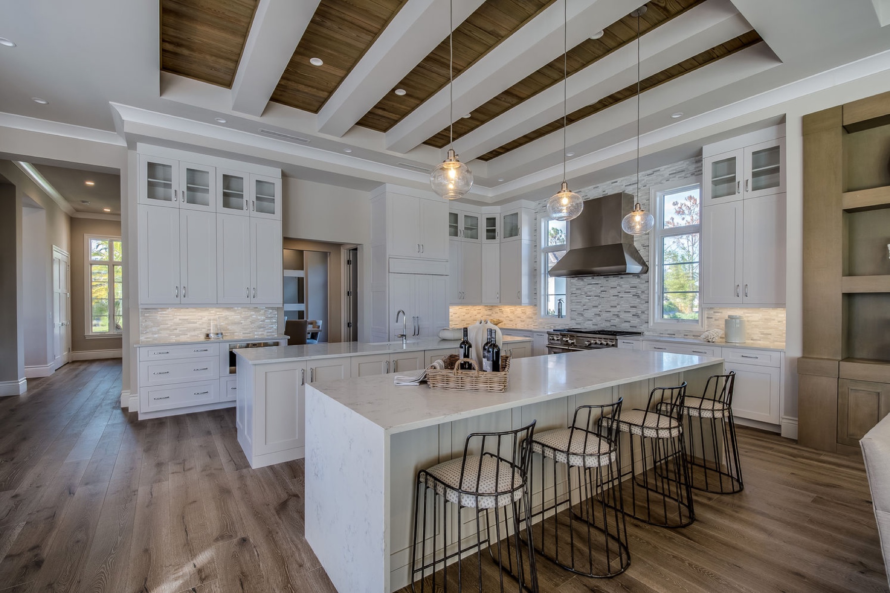 Luxury white kitchen with coffered wood ceiling and marble island