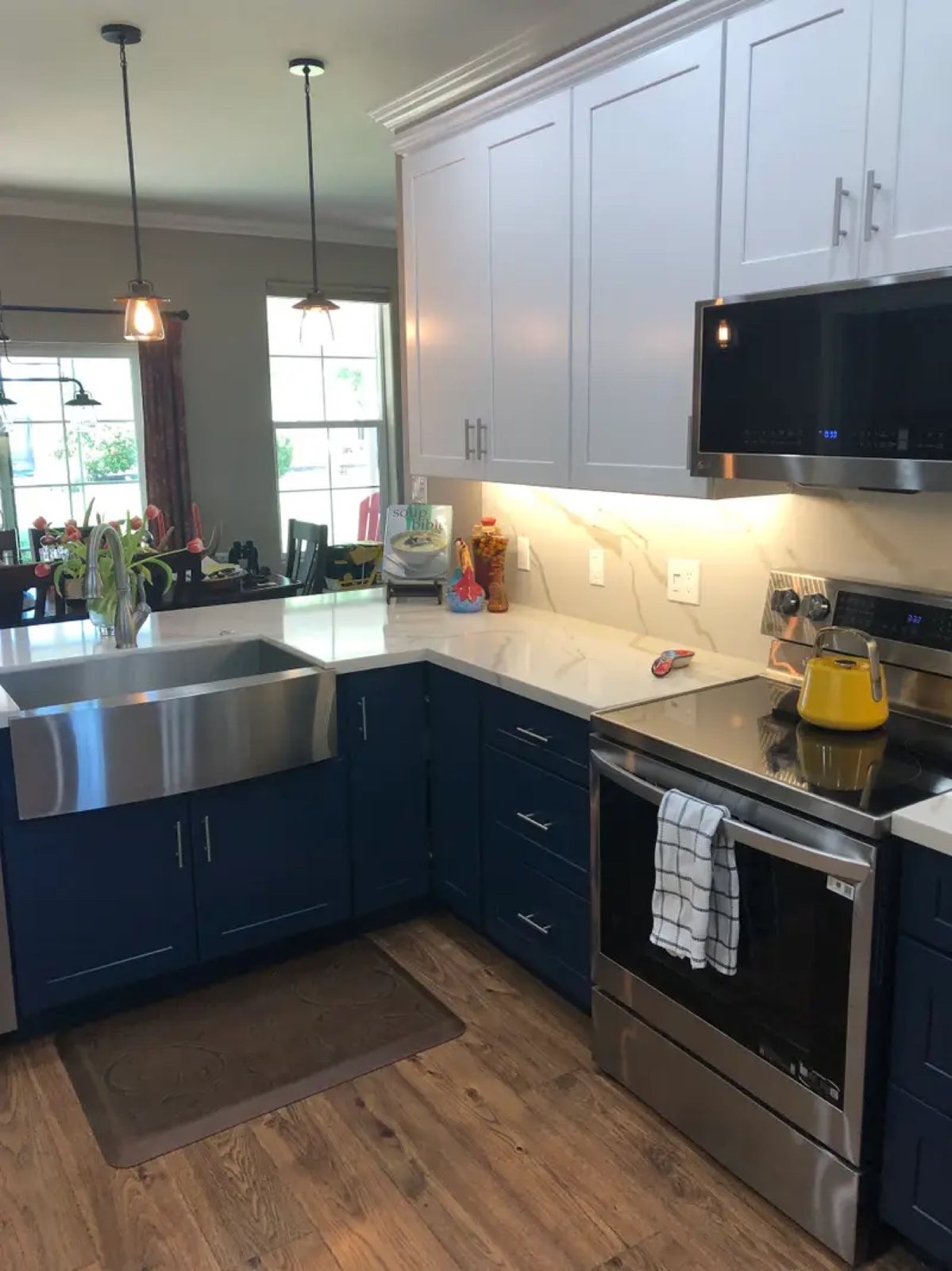 Navy blue kitchen with farmhouse sink and marble backsplash