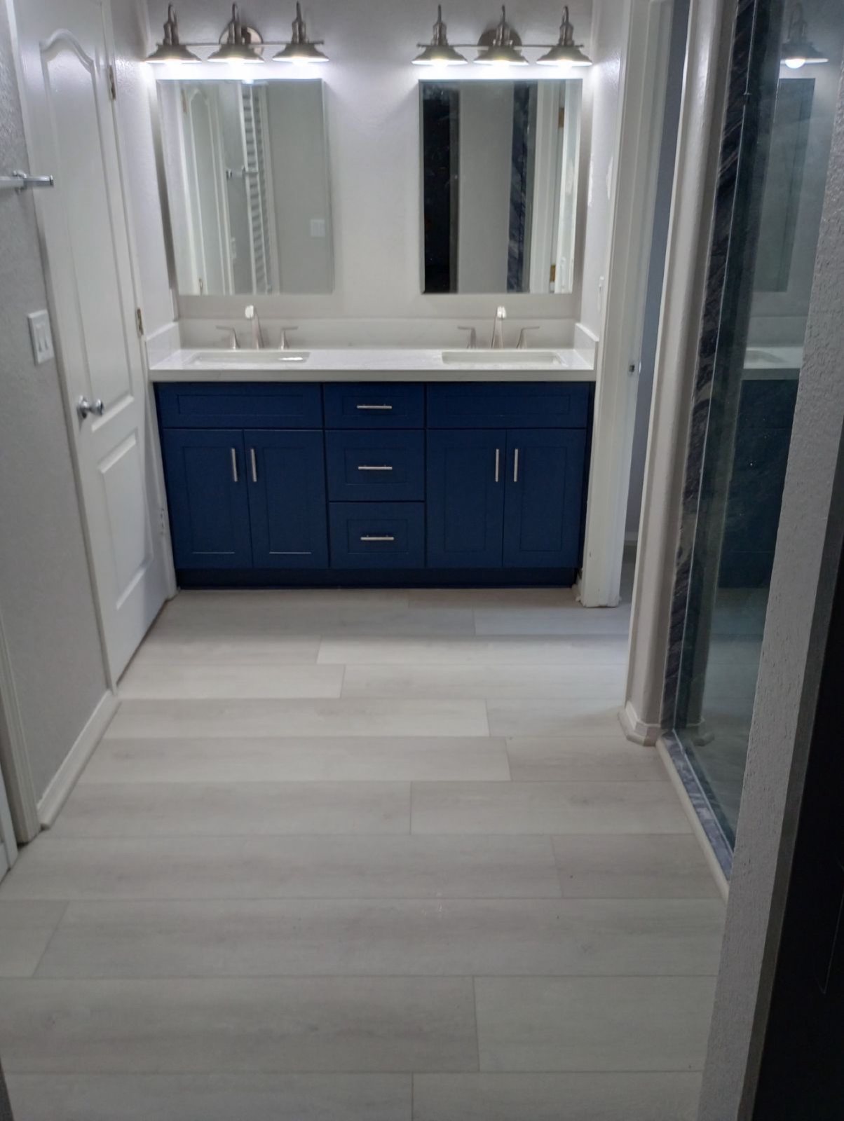 Navy blue double vanity with white quartz and tile floor