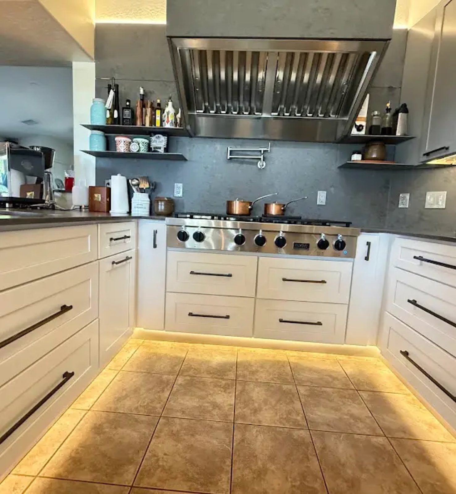 White kitchen with professional range and stainless hood